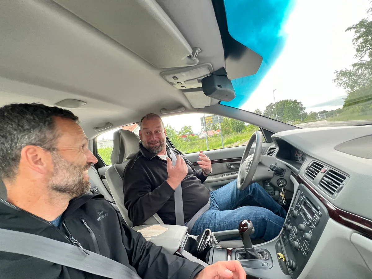 Zwei Männer sitzen in einem Auto.